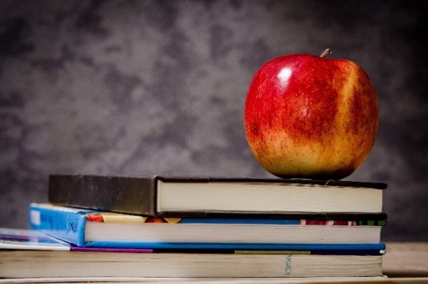 An apple balancing on a stack of books